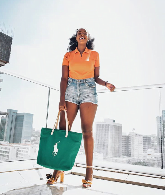 Denim shorts paired with a statement green bag